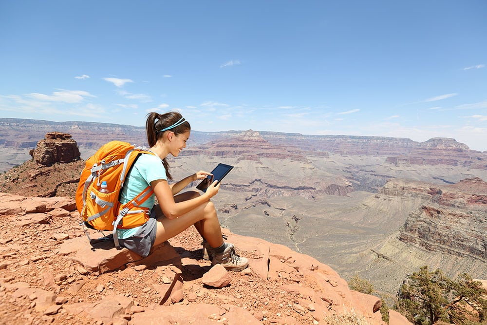 woman backpacking in desert on phone