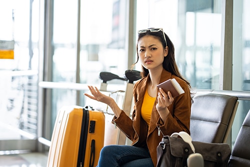 woman in airport looking annoyed